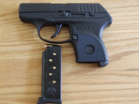 2002 Jeep TJ - A black Ruger LCP pistol is shown next to its magazine on a wooden surface.