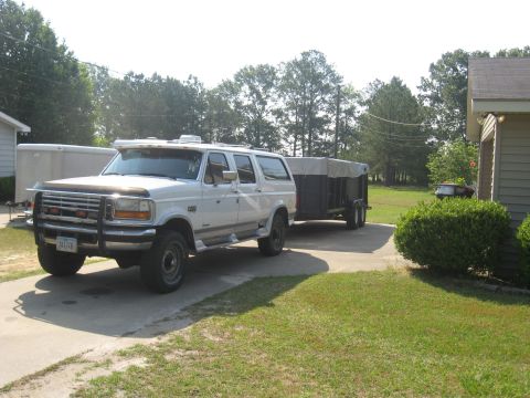 1995 Ford C-350 (Centurion Conversions) - White 1995 Ford C-350 (Centurion Conversions) SUV is parked on a driveway, towing a trailer.