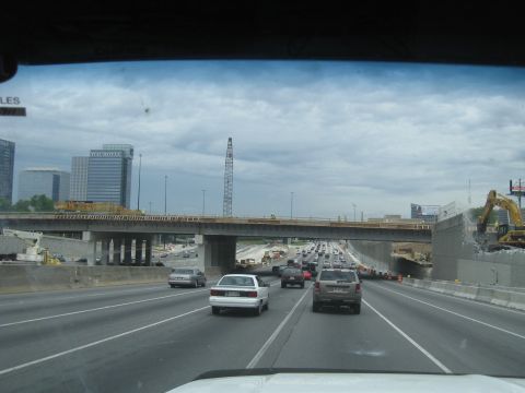 1995 Ford C-350 (Centurion Conversions) - A highway scene with ongoing construction, including an excavator and traffic on-road traffic under a cloudy sky.