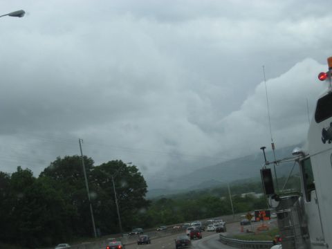 1995 Ford C-350 (Centurion Conversions) - A white truck cab is visible on the right side of the frame, driving on a highway under a cloudy sky.