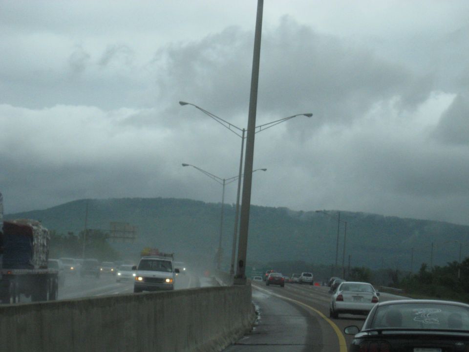 Highway traffic on a rainy day with mountains in the background