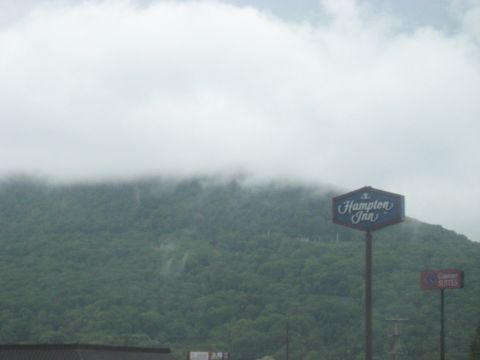 1995 Ford C-350 (Centurion Conversions) - A sign for Hampton Inn stands against a backdrop of a misty, tree-covered mountain.
