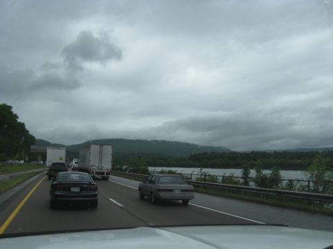 1995 Ford C-350 (Centurion Conversions) - Driving on a highway with multiple vehicles and a scenic view of water and hills.
