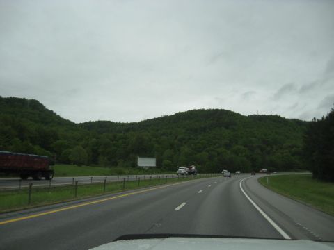1995 Ford C-350 (Centurion Conversions) - View from a vehicle on a highway passing by green hills and other vehicles.