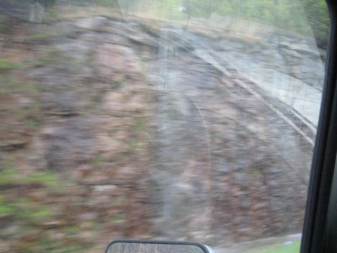 1995 Ford C-350 (Centurion Conversions) - Moving past a rocky hillside with vegetation visible through the vehicle's window.
