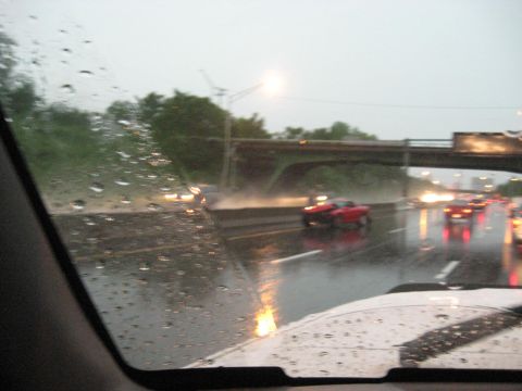 1995 Ford C-350 (Centurion Conversions) - Driving on a wet highway during a rainstorm with multiple vehicles on the road.