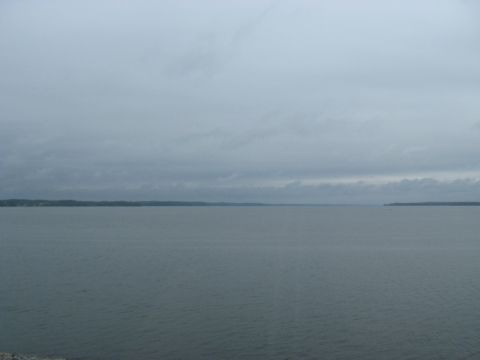 1995 Ford C-350 (Centurion Conversions) - A vast expanse of water under a cloudy sky, with land visible on the horizon.