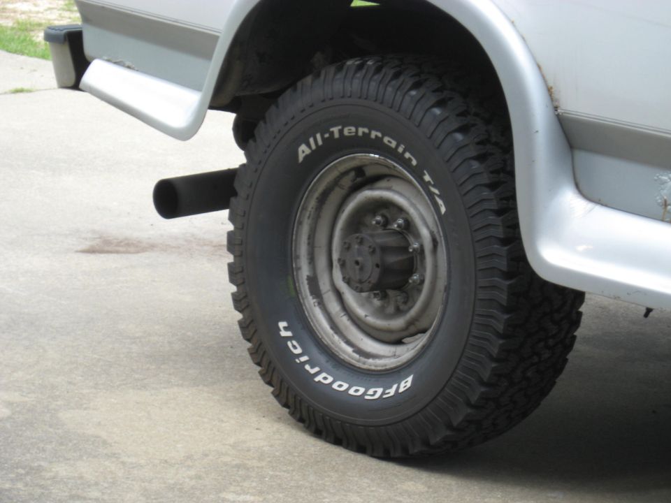 BFGoodrich All-Terrain T/A tire on a vehicle's rear wheel, with exhaust pipe visible