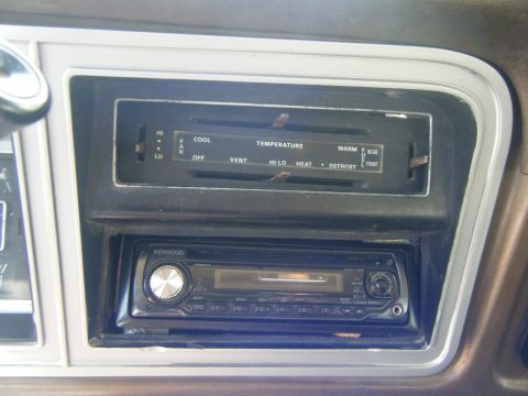 1979 Ford Bronco - Close-up of the dashboard showing the climate control panel and an aftermarket stereo system.