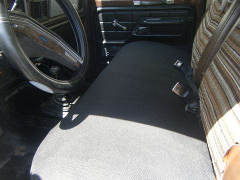 1979 Ford Bronco - Interior view of a 1979 Ford Bronco, showing the bench seat, steering wheel, and door panel.