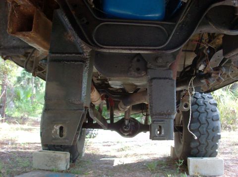 1989 Ford Bronco - Undercarriage view showing suspension components and large tires on a modified vehicle.
