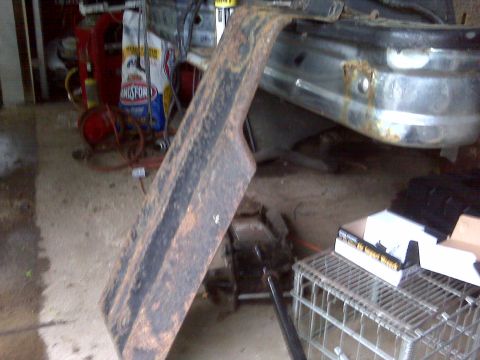 1995 Ford Bronco - A close-up view of a rusted fender flare and a damaged chrome bumper.