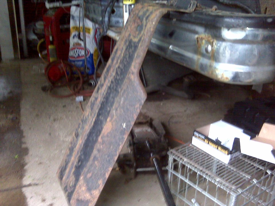 Rusted metal fender flare and chrome bumper with rust spots