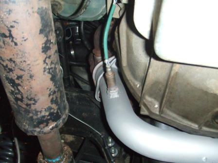 1996 Ford Bronco - Close-up of an exhaust pipe and oxygen sensor, likely from a vehicle's engine bay or undercarriage.
