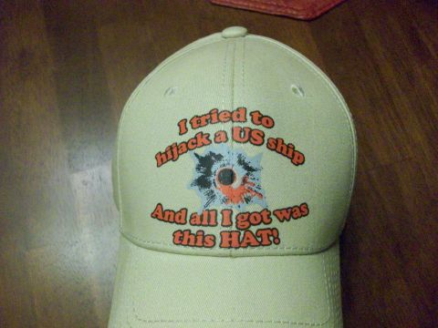1995 Ford Bronco - A tan baseball cap features text and a graphic depicting a bullet hole, humorously stating the wearer's unsuccessful attempt to hijack a US…