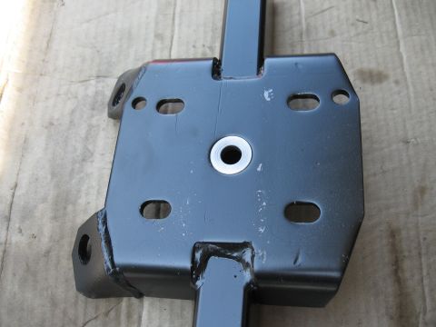 1968 Shelby GT500 - Close-up of a black metal bracket, likely for a rear axle traction bar, with mounting holes.