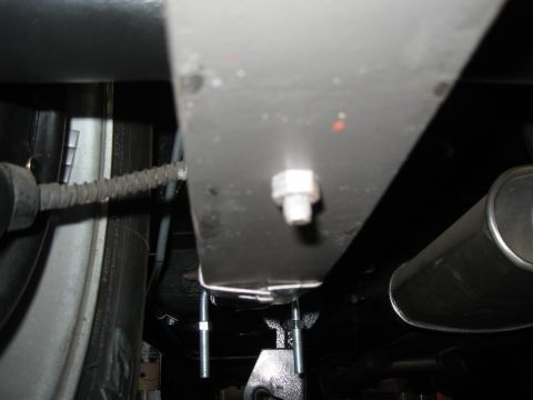 1968 Shelby GT500 - Underside view of a vehicle's suspension system, focusing on the installation of traction bars.
