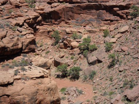 1986 Ford Bronco II - An off-road vehicle navigates a challenging rocky path in a desert canyon.