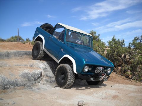 1986 Ford Bronco II - This classic Ford Bronco navigates a challenging rocky trail under a clear blue sky.