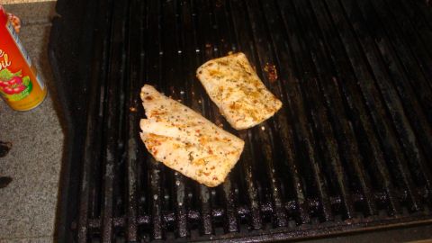 1996 Ford Bronco - Fish fillets cook on a grill, with a can of cooking spray visible on the left side.