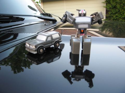 1986 Ford Bronco - Toy robot and toy SUV are placed on the hood of a car.