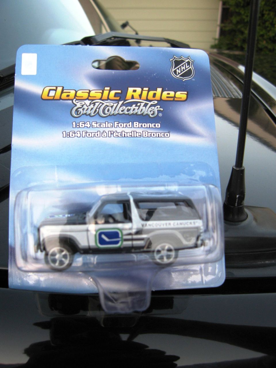 Diecast 1:64 scale Ford Bronco in blister pack, white and grey with green and blue decals