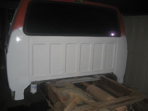 1983 Ford F-250 - Rear view of a truck bed undergoing body work, showing the white painted panels and rusty chassis.