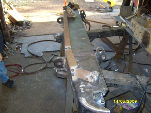 1989 Ford Bronco - A close-up view of a vehicle's frame undergoing modifications in a workshop setting.