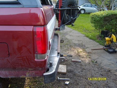 1989 Ford Bronco - Rear view of a red SUV, likely a 1989 Ford Bronco, showing its bumper and a spare tire carrier mounted on the back.