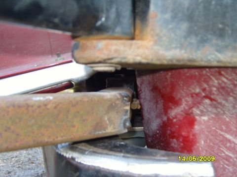 1989 Ford Bronco - Close-up view of the rusty metal bracket and frame components of a vehicle.
