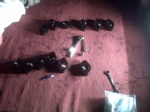 2008 Jeep Wrangler - Several black engine components are laid out on a red surface with a wrench and a pen.