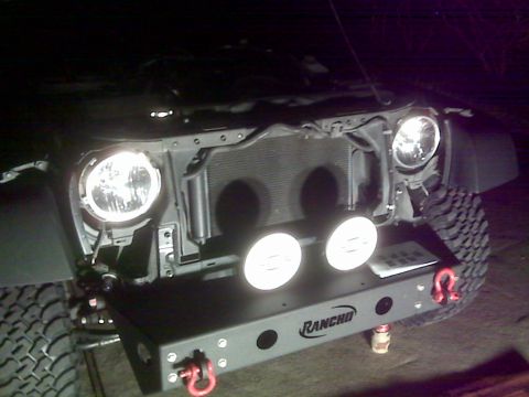 2008 Jeep Wrangler - Night shot of a Jeep JK front end with the grille removed, headlights and two round driving lights lit up and the radiator and cooling fans…