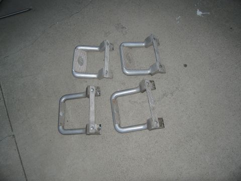 1986 Ford Bronco - A set of four vehicle running boards are displayed on a gray concrete floor.