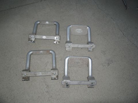 1986 Ford Bronco - Four aftermarket step bars are laid out on a concrete floor, likely for sale or installation.