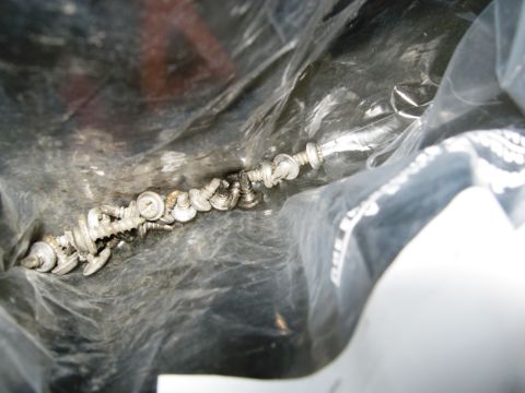 1986 Ford Bronco - A collection of various screws and fasteners are visible inside a plastic bag.