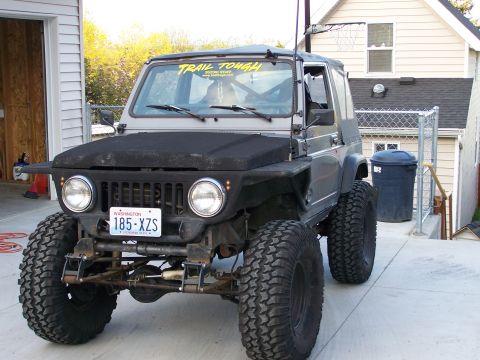 1988 Suzuki Samurai - Modified 1988 Suzuki Samurai parked in a driveway with a "TRAIL TOUGH" sticker on the windshield.