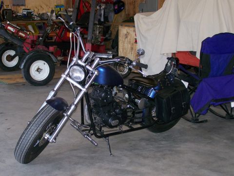1988 Suzuki Samurai - A custom blue motorcycle with saddlebags sits in a garage, with other equipment visible in the background.