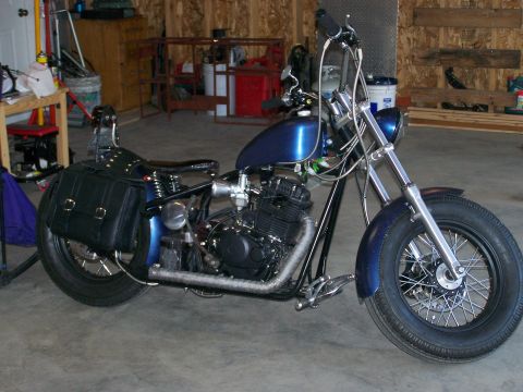 1988 Suzuki Samurai - A custom blue motorcycle with black saddlebags is parked inside a garage.