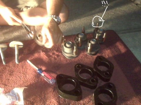 2008 Jeep Wrangler - Various lift kit components and tools are laid out on a red cloth, suggesting an ongoing vehicle modification project.