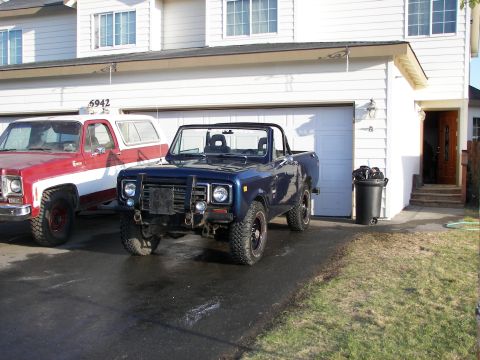 1990 Chevrolet Suburban - Two trucks are parked in front of a house and garage.
