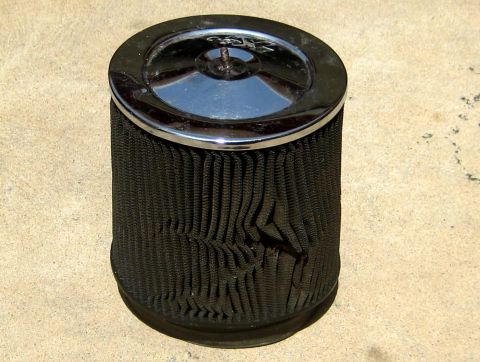 1996 Ford Bronco - A K&N air filter with a chrome top sits on a textured surface.