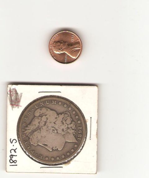 1995 Ford Bronco - A silver dollar coin from 1892 is shown next to a modern penny.