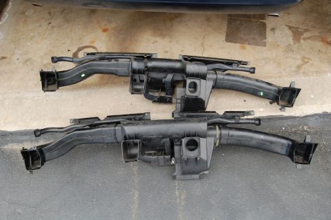 1985 Mercury Grand Marquis - Two automotive HVAC duct assemblies are shown side-by-side on a concrete surface.
