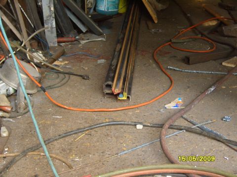 1989 Ford Bronco - A cluttered workshop scene shows various tools and materials on the concrete floor.