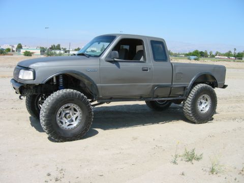 1997 Ford Ranger - Modified gray Ford Ranger pickup truck sits on a dirt lot under a clear blue sky.