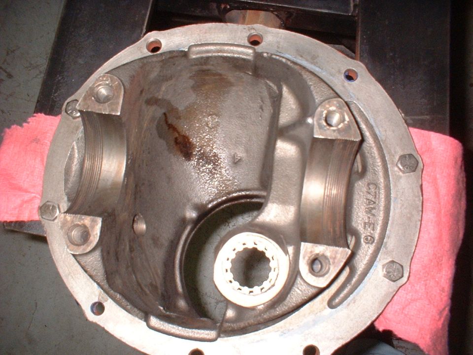Differential housing with bearing caps and splined yoke. Metal casting shows oil stains