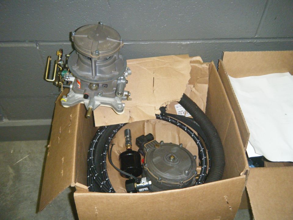 carburetor and fuel pump parts in a cardboard box