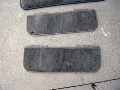 1986 Ford Bronco - Two gray carpeted floor mats are shown laid out on a concrete surface.