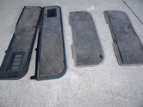 1986 Ford Bronco - These four interior door panels, likely from a truck or SUV, are laid out on a concrete surface.
