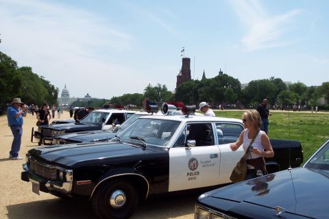 2001 Ford Crown Victoria - Vintage police cars, including one marked 'POLICE 85012', are parked with the US Capitol building in the distance.